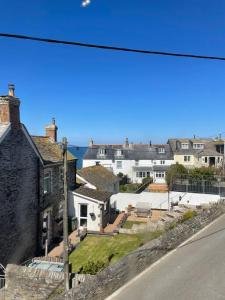a group of houses with the ocean in the background at Atlantic Cottage Port Isaac 2 bedroom with parking in Port Isaac