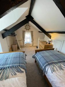 a attic bedroom with two beds and a window at Atlantic Cottage Port Isaac 2 bedroom with parking in Port Isaac