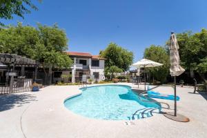 einen Pool mit Sonnenschirm und Sonnenschirm in der Unterkunft Beautiful 2 BR Mesa Riverview Apt, Close to 202 HW! in Mesa