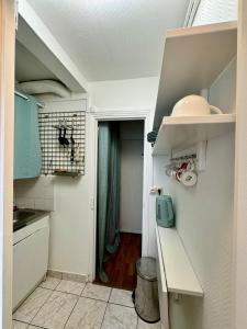 a small kitchen with blue cabinets and a hallway at Paris - Appartement 50m2 - Tour Eiffel in Paris