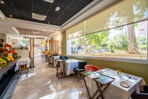 a restaurant with tables and chairs and a large window at Avenida Hotel in Almería