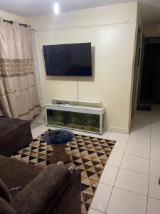 a living room with a couch and a flat screen tv at Tawakal airbnb in Thika