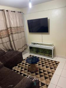 a living room with a tv and a fish tank at Tawakal airbnb in Thika