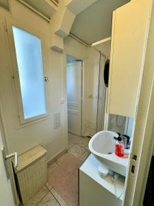 a bathroom with a white sink and a window at Paris - Appartement 50m2 - Tour Eiffel in Paris