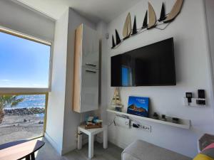 a living room with a flat screen tv on a wall at Vacacional Sunbeach Candelaria in Candelaria