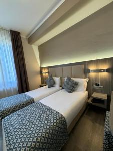 Habitación de hotel con 2 camas y ventana en Delle Nazioni Milan Hotel en Milán