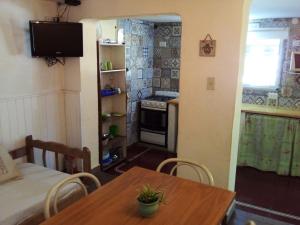 a room with a table and a kitchen with a stove at Alojamiento frente al Arroyo Cristal in Tanti
