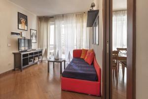 Opi's home with terrace في بوكيناسكو: غرفة معيشة بها أريكة حمراء وتلفزيون