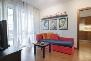 Opi's home with terrace في بوكيناسكو: غرفة معيشة مع أريكة حمراء وطاولة