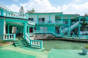une maison bleue avec une piscine en face de celle-ci dans l'établissement Ocean Front Triple Room at Sahara Hotel, à Montego Bay