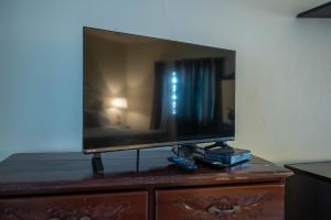 Ocean Front Triple Room at Sahara Hotel في خليج مونتيغو: يوجد تلفزيون بشاشة مسطحة فوق خزانة ملابس