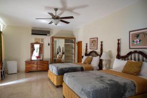- une chambre avec 2 lits et un ventilateur de plafond dans l'établissement Ocean Front Triple Room at Sahara Hotel, à Montego Bay