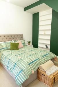 a bedroom with a large bed with a green wall at Vibrant Two Bedroom House near Canary Wharf in London