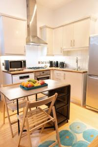 a kitchen with a table with a bowl of fruit on it at Vibrant Two Bedroom House near Canary Wharf in London