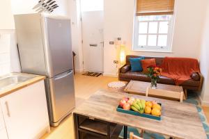 a kitchen with a refrigerator and a table with a bowl of fruit at Vibrant Two Bedroom House near Canary Wharf in London