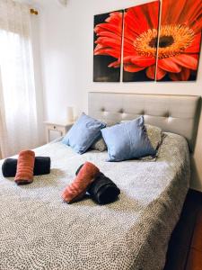 Un dormitorio con una cama con almohadas y una pintura en La Casa de Las Flores, en Tacoronte