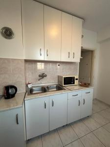 a kitchen with white cabinets and a sink at Kelti in Belgrade