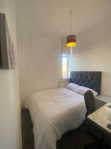 a bedroom with a large white bed and a desk at Cozy One Room- Ideal for Getaways in Bury