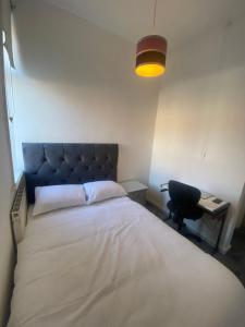 ein Schlafzimmer mit einem Bett, einem Schreibtisch und einer Lampe in der Unterkunft Cozy One Room- Ideal for Getaways in Bury
