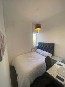 Schlafzimmer mit einem großen weißen Bett und einem Schreibtisch in der Unterkunft Cozy One Room- Ideal for Getaways in Bury