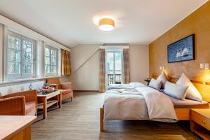 une chambre d'hôtel avec un lit et un canapé dans l'établissement Seehotel Zarrentin, à Zarrentin