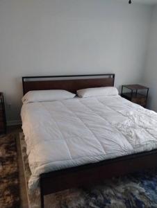 een bed met witte lakens en kussens in een slaapkamer bij Cozy cottage in White Hall