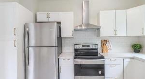una cucina con armadi bianchi e frigorifero in acciaio inossidabile di Modern Chateau Remodeled Home Close to Downtown a Mobile