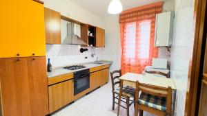 een keuken met een tafel en een fornuis top oven bij Appartamento al Mare in Chioggia