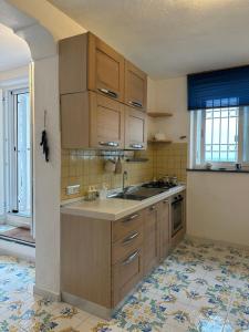 a kitchen with wooden cabinets and a sink at LA BOMBONIERA in Ischia