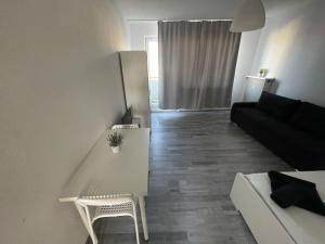 a white living room with a couch and a table at FEE Apartment 1 Bremerhaven in Bremerhaven