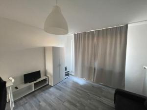 a living room with a television and a large window at FEE Apartment 1 Bremerhaven in Bremerhaven