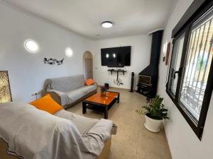 ein Wohnzimmer mit Couch und Fernseher in der Unterkunft Marvelous Ador Dream Villa with Wifi, 3 Bedrooms And Swimming Pool in Ador