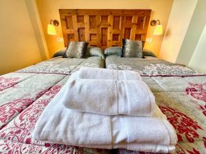 ein Hotelzimmer mit zwei Betten, auf denen Handtücher liegen in der Unterkunft Navalpinar in Navalmanzano