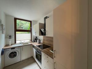 a kitchen with a washing machine and a window at Apartment Gerberbachviertel in Weinheim