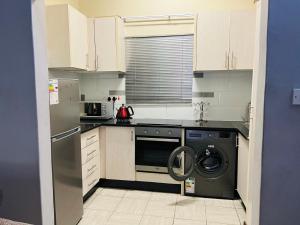 a kitchen with a washer and dryer in it at Brilliant Home in Gaborone