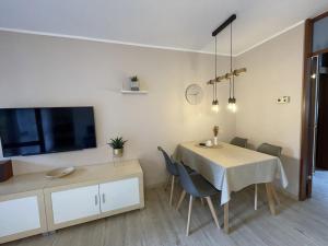 a dining room with a table with chairs and a tv at Apartment Gerberbachviertel in Weinheim