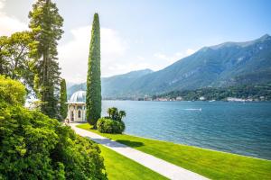 a view of a lake with a house and trees at Grand Hotel Villa Serbelloni - A Legendary Hotel in Bellagio