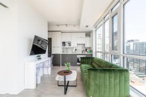 トロントにあるExecutive Suites - Toronto's Entertainment Districtのリビングルーム(緑のソファ付)、キッチンが備わります。