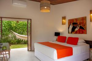 um quarto com uma cama com almofadas vermelhas em Pousada Vila Cobé em Japaratinga