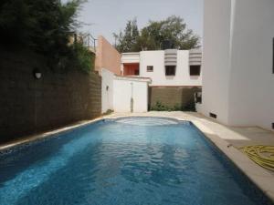 una piscina di fronte a una casa di Appartement F3 Almadies vue/mer accès+ Dakar a Dakar