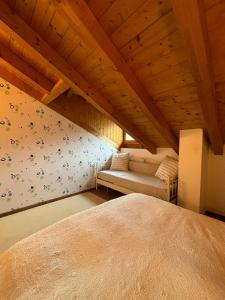 een slaapkamer met een bed en een bank in een kamer bij Casa Celeste Ledro in Ledro