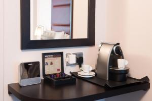 
a desk with a computer and a cup on it at Mercure London Kensington Hotel in London
