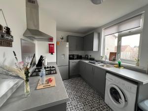 a kitchen with a washer and dryer in it at Holborn in Coundon