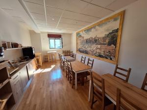 una sala da pranzo con tavolo, sedie e un dipinto di Boutique Hostel Livia a Metković