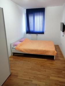 een slaapkamer met een bed in een kamer met een raam bij N apartman in Obrenovac