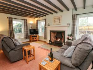 a living room with a couch and a fireplace at Garden Cottage in Penrith