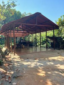 a large wooden pavilion with a table under it at Private waterfall and indigenous house! in Minca