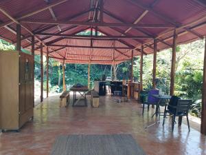 a large pavilion with tables and chairs in at Private waterfall and indigenous house! in Minca