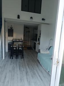 a room with a table and a bed and a kitchen at Studio avec mezzanine in Saint-Georges-de-Didonne +4 photos