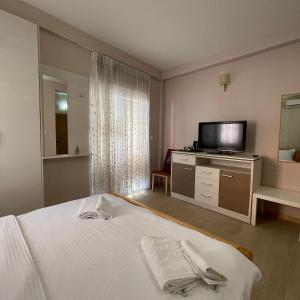 um quarto de hotel com uma cama e uma televisão de ecrã plano em Di Angolo Apartments em Ohrid